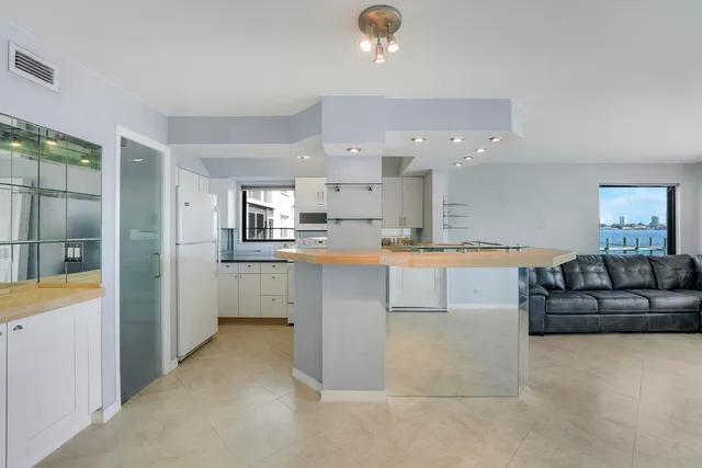 a kitchen with kitchen island granite countertop a refrigerator and a stove top oven