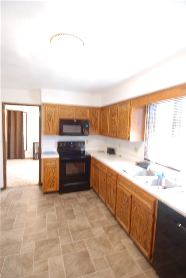 4091 Montclair Road Roscoe, IL 61073 - Photo 5 of 12 a large kitchen with kitchen island granite countertop a sink and a stove