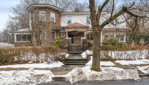 a front view of a house with a yard covered with snow