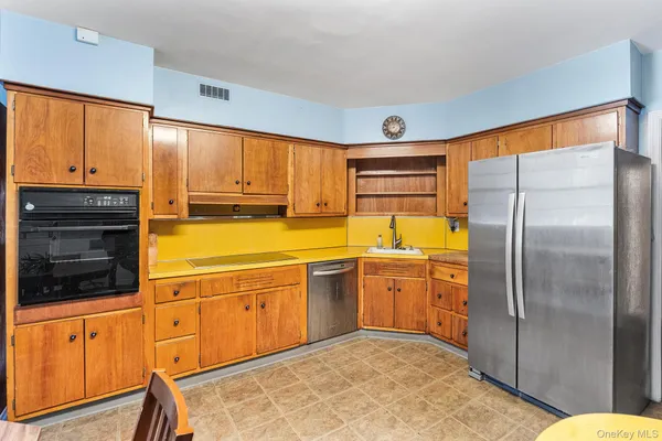 a kitchen with stainless steel appliances granite countertop a refrigerator a oven and a stove