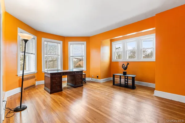 a view of a bedroom with wooden floor and a sink