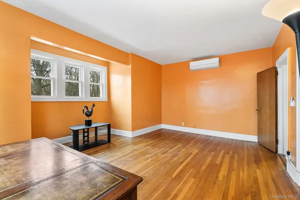 a living room with furniture a large window and wooden floor