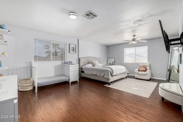 a bedroom with a bed wooden floor and a window