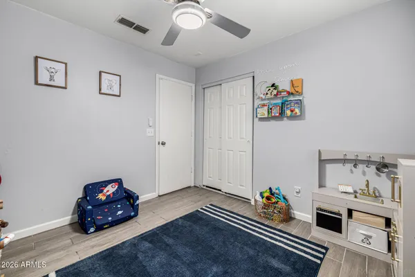 a bedroom with bed and ceiling fan