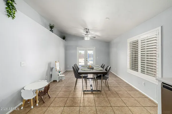 a dining room with chandelier and wooden floor