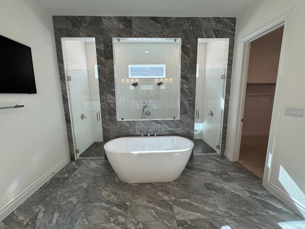 309 Wolf Rdg Road Georgetown, TX 78628 - Photo 13 of 25 Bathroom featuring a freestanding bath, a spacious closet, a dual head walk in shower, and dark marble finish flooring