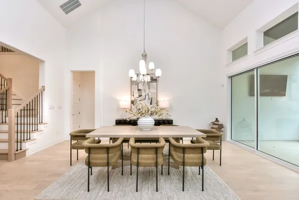 a living room with furniture kitchen view and a chandelier