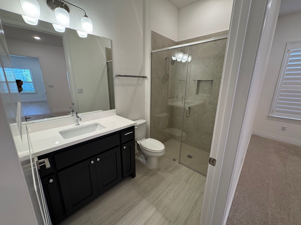 309 Wolf Rdg Road Georgetown, TX 78628 - Photo 19 of 25 Bedroom 2 -"Mother in law" suite Full bathroom with vanity, a shower stall, and tile