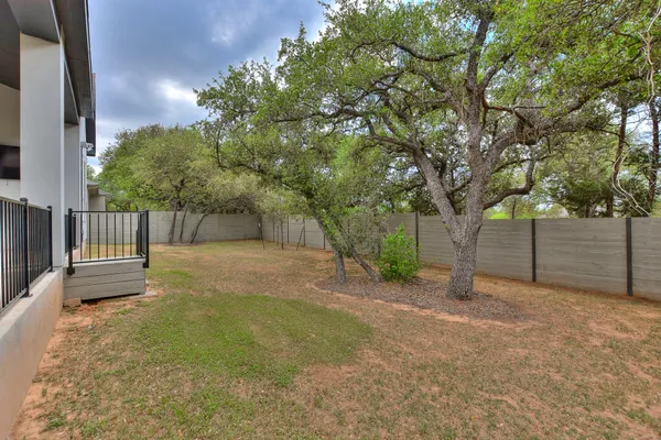 a view of a yard with wooden fence