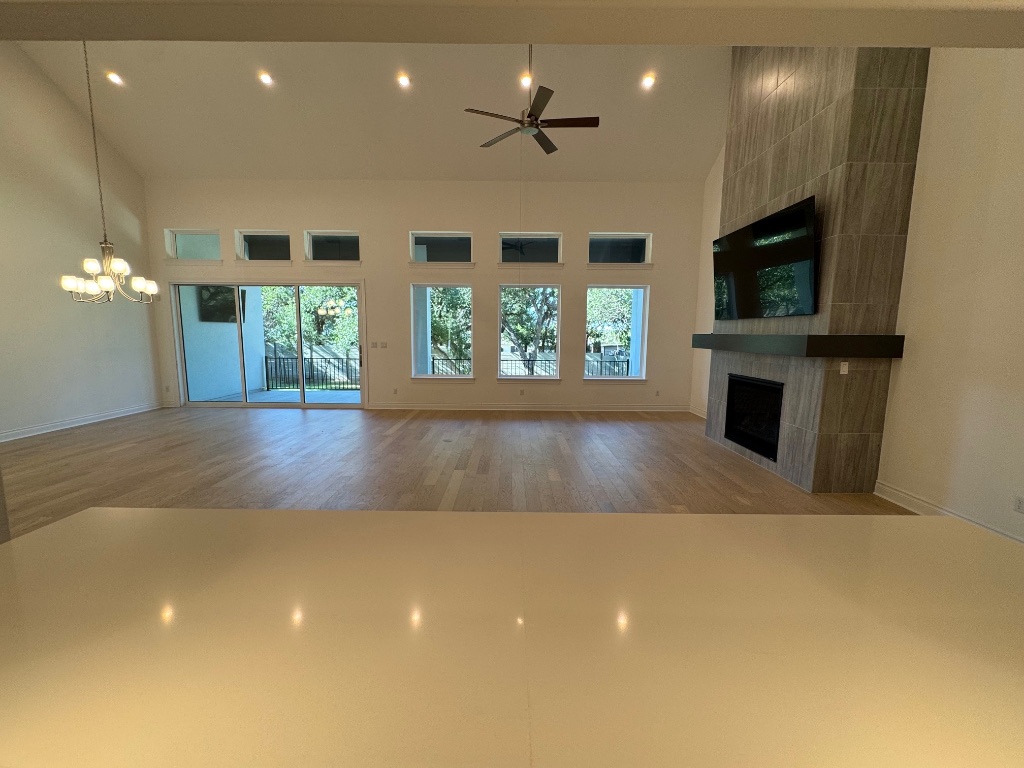 309 Wolf Rdg Road Georgetown, TX 78628 - Photo 7 of 25 Open concept living room with a gas log fireplace, healthy amount of natural light, a towering ceiling, recessed lighting, and a ceiling fan