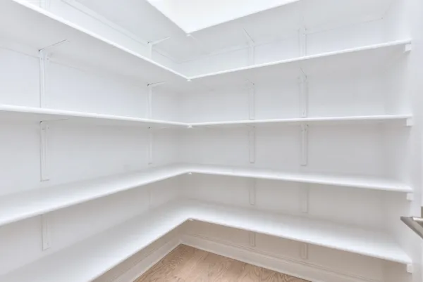a large white kitchen with a large window a sink stainless steel appliances and cabinets