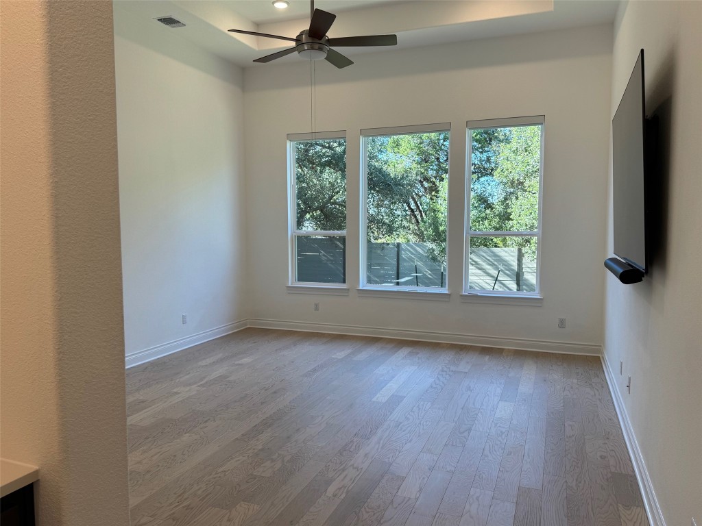 309 Wolf Rdg Road Georgetown, TX 78628 - Photo 10 of 25 wood floors, healthy amount of natural light, tray ceiling, a ceiling fan, and recessed lighting