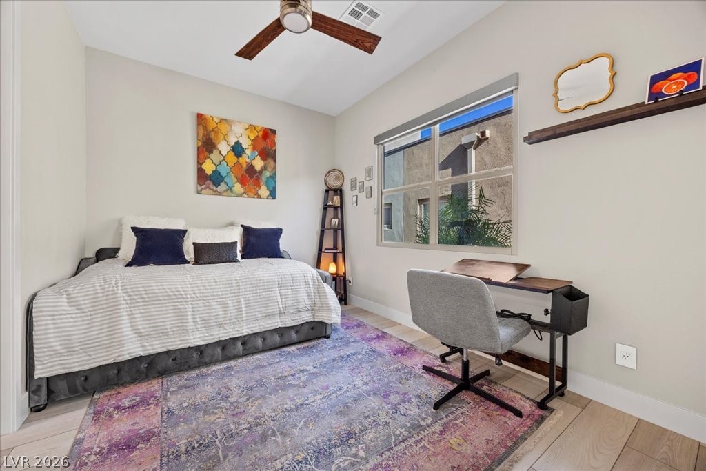 4262 Swift Street Las Vegas, NV 89135 - Photo 24 of 75 Bedroom with ceiling fan, light wood-style flooring, and a desk