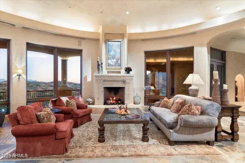 a living room with fireplace furniture and a large window
