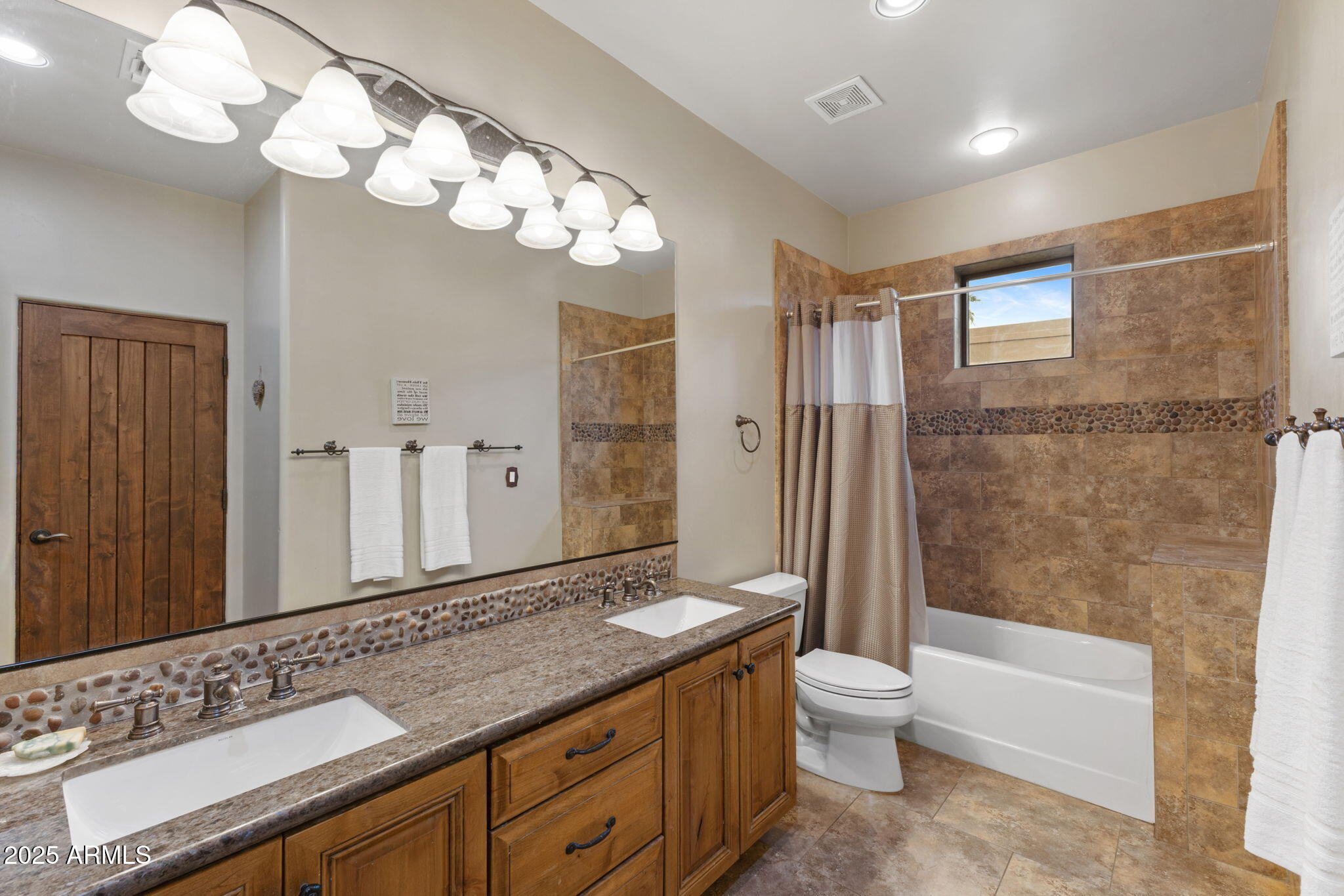 8821 North 9th Avenue Phoenix, AZ 85021 - Photo 24 of 36 a bathroom with a granite countertop sink a toilet a mirror a bathtub and shower