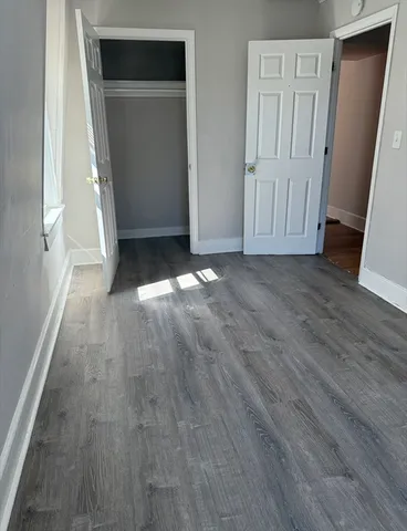 an empty room with wooden floor and closet