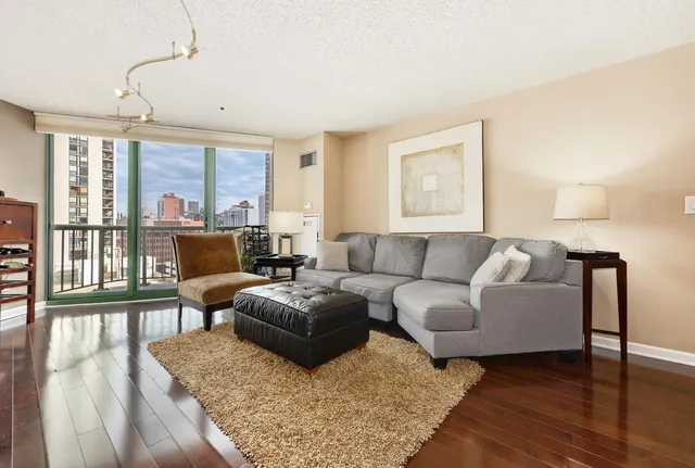 a living room with furniture wooden floor and a large window