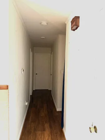 a view of a hallway with wooden floor