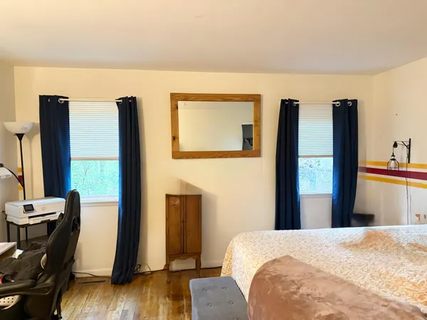 a bedroom with a bed and wooden floor