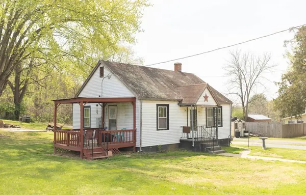 a backyard of a house with table and chairs
