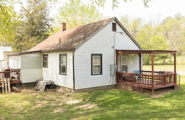 a view of a house with a yard and deck