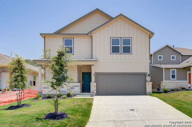 a front view of a house with a yard and garage