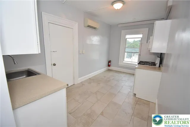 a room with granite countertop white cabinets and a sink