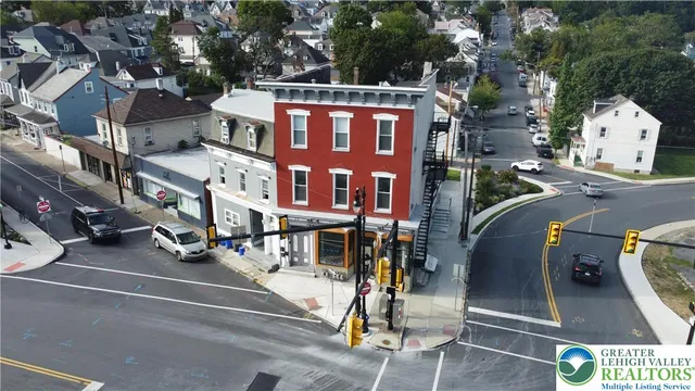 a city view with tall buildings and cars parked on the roadside