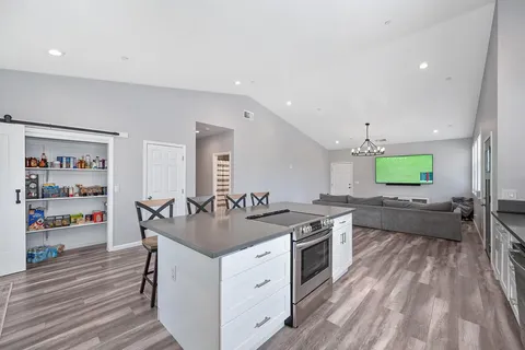 a kitchen with a stove and a wooden floor
