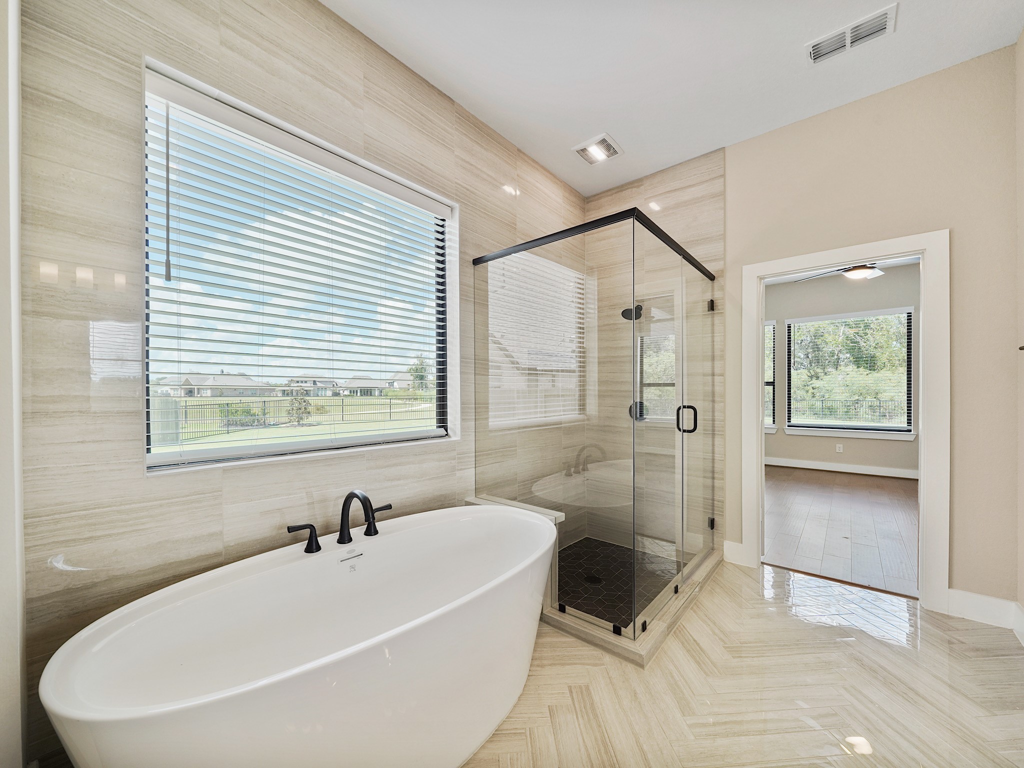 30214 Crossfield Road Fulshear, TX 77441 - Photo 19 of 42 A second perspective captures the bright window, frameless glass shower, and clean, elevated finish of the primary bath.