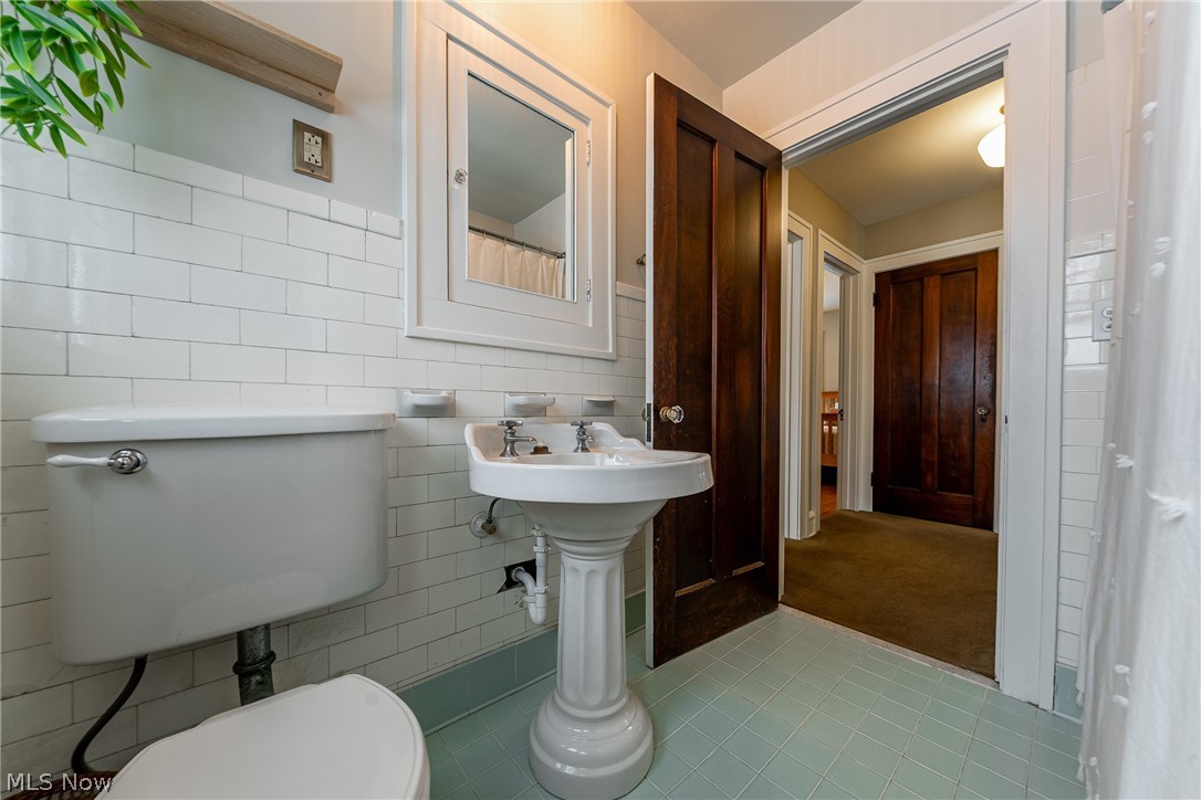 2904 Clarkson Road Cleveland Heights, OH 44118 - Photo 22 of 43 Full bath with curtained shower, tile walls, and light tile patterned flooring
