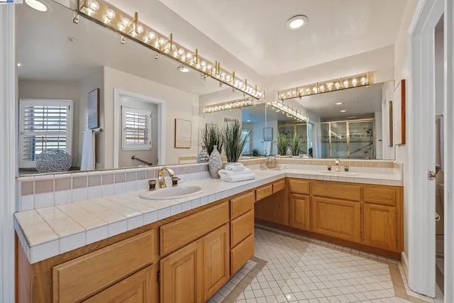 a bathroom with a sink double vanity granite tub and shower