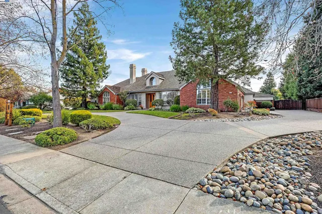 a front view of a house with a yard and trees