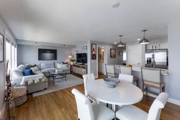 a living room with furniture kitchen view and a flat screen tv