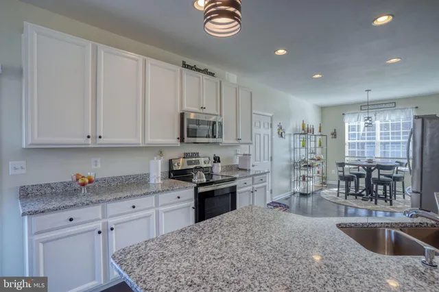 a dining room with furniture potted plants and wooden floor