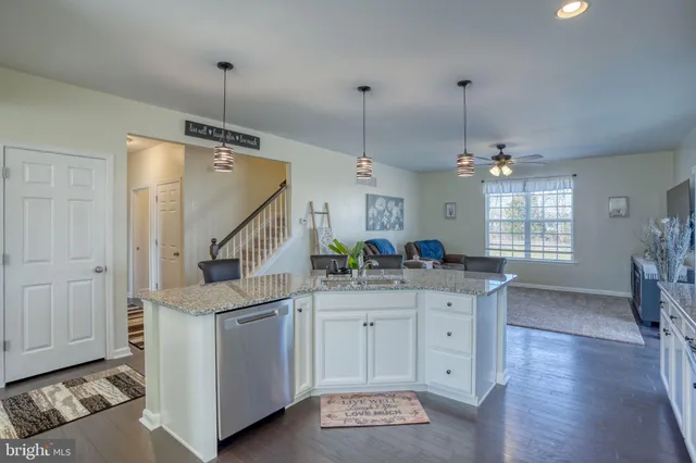 a large kitchen with kitchen island a counter space a sink stainless steel appliances and cabinets