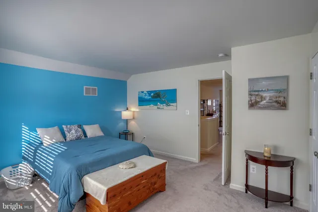 a bedroom with a bed a chair and next to a window