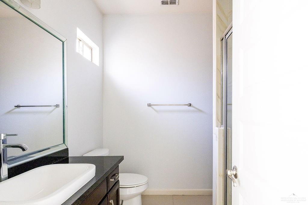 1707 West Smith Drive, Unit 2 Pharr, TX 78577 - Photo 11 of 14 a white toilet sitting next to a bathroom sink