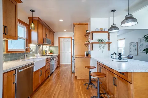 a kitchen with stainless steel appliances granite countertop a sink a stove and a wooden floors