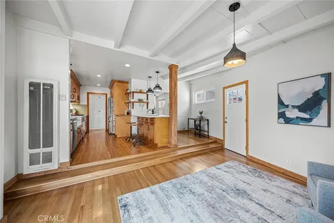a view of a living room and kitchen with furniture wooden floor and a fireplace
