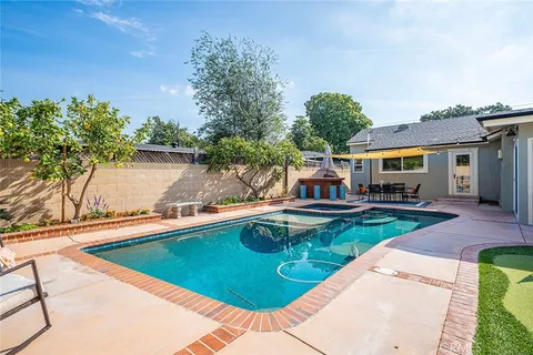 swimming pool view with a seating space and a garden view