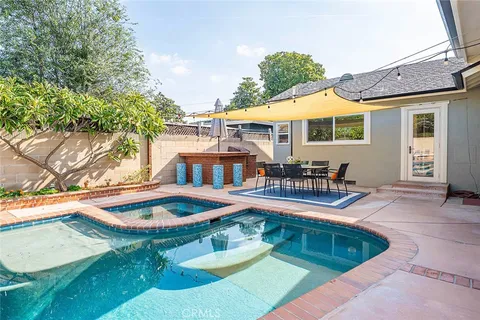 a view of a patio with table and chairs potted plants and a barbeque