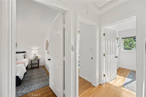 a view of a bedroom with a bed and wooden floor