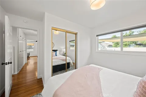 a bedroom with a bed and wooden floor