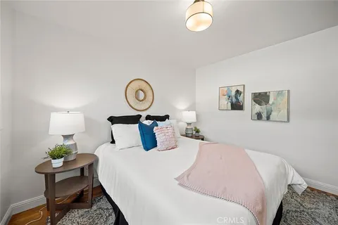 a bedroom with bed and wooden floor