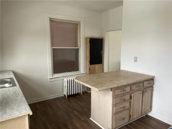 a kitchen with a wooden floor and white cabinets