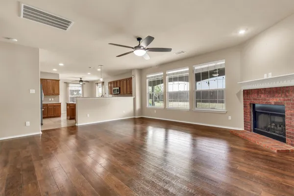 a view of a big room with wooden floor a fireplace and a window