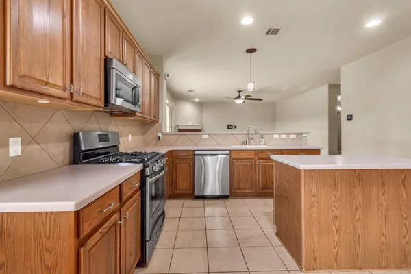 a kitchen with a sink stove top oven and cabinets