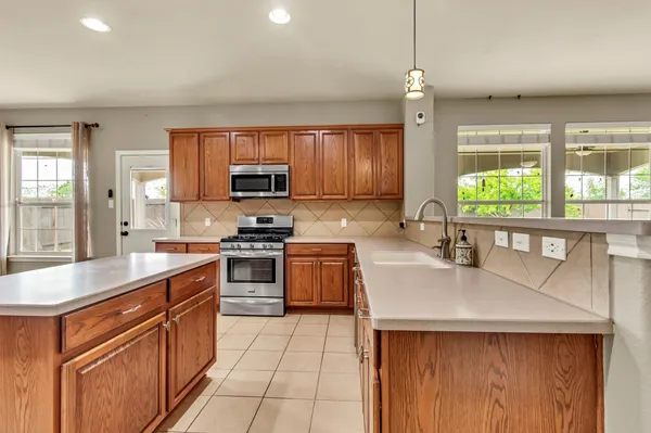 a kitchen with stainless steel appliances granite countertop a sink stove and refrigerator