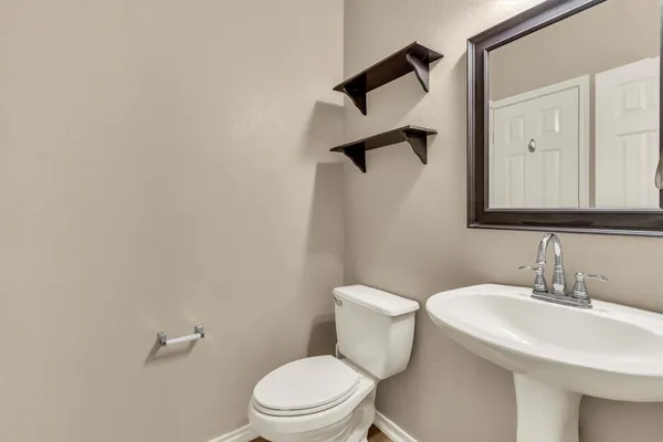 a bathroom with a toilet a sink and mirror